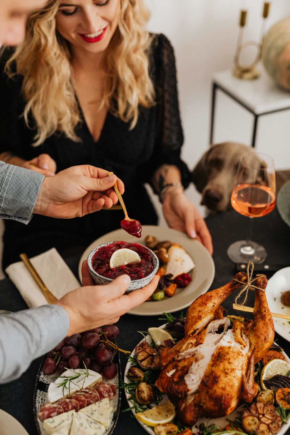 Friends passing dishes at a holiday dinner
